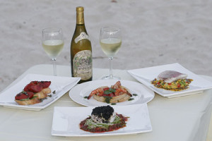 bottle of wine and food served on beach