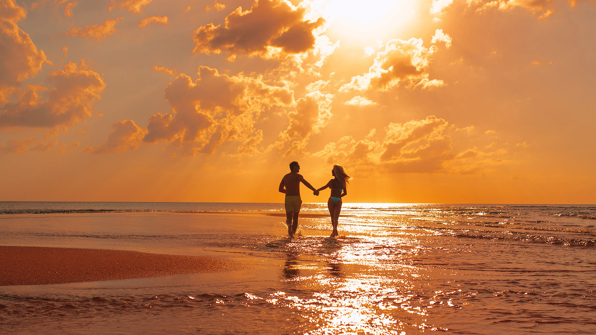 Couple Walking On Beach At Sunset